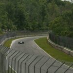 A race car speeds around a winding track.